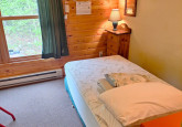 Dorm room with twin bed and a full/twin bunk, lots of hooks, three dressers and a partial clothes hanger nook at Wildflower Cabin #10 at Crow Wing Crest Lodge in Akeley, MN