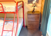 Dorm room with twin bed and a full/twin bunk, lots of hooks, three dressers and a partial clothes hanger nook at Wildflower Cabin #10 at Crow Wing Crest Lodge in Akeley, MN