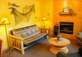 Cabin 10 living room with gas fireplace and sofa bed at Crow Wing Crest Lodge in Akeley, MN